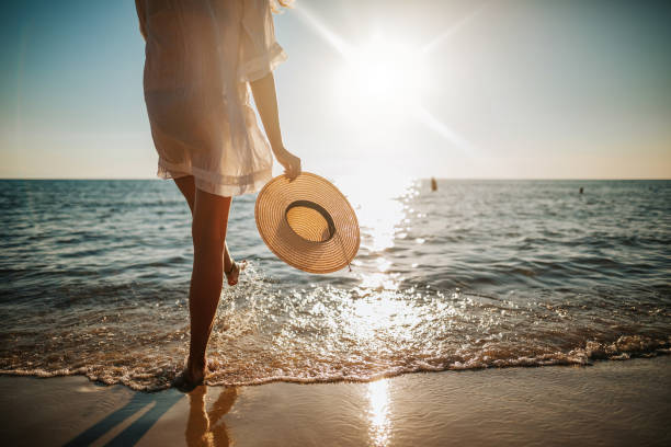 Femme qui marche pied nus sur la plage